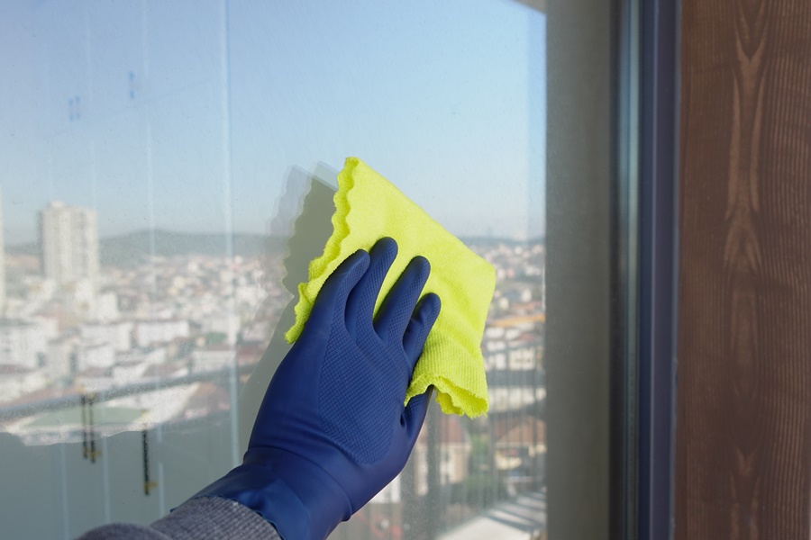 Técnica de inspección visual de reflejos durante la limpieza como parte de cómo saber si un cristal es templado en casa.